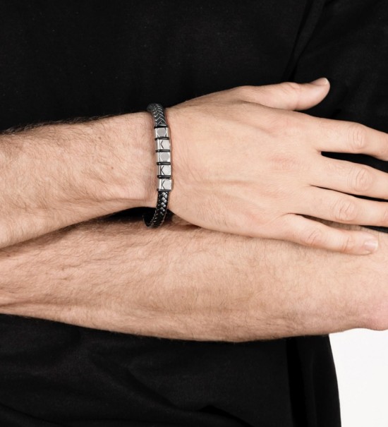Brazalete Lotus Style para hombre con piel negra trenzada y detalles de acero inoxidable. Diseño masculino moderno y elegante.