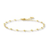 Tobillera de acero dorado con delicadas bolas decorativas y diseño minimalista elegante.