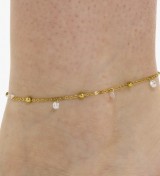 Tobillera de acero dorado con colgantes de circonitas brillantes y diseño elegante para mujer.